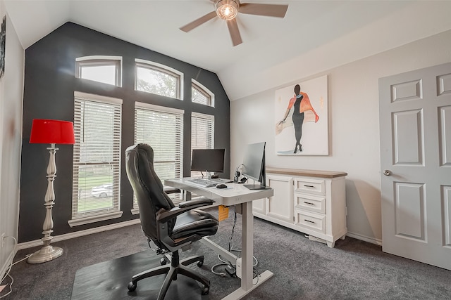 home office with plenty of natural light, ceiling fan, vaulted ceiling, and dark colored carpet