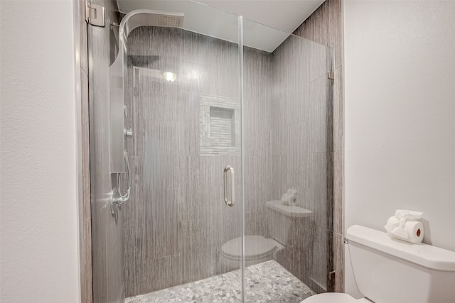 bathroom featuring toilet and an enclosed shower