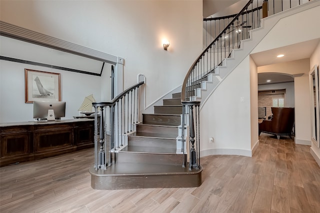 stairs featuring a high ceiling and hardwood / wood-style floors