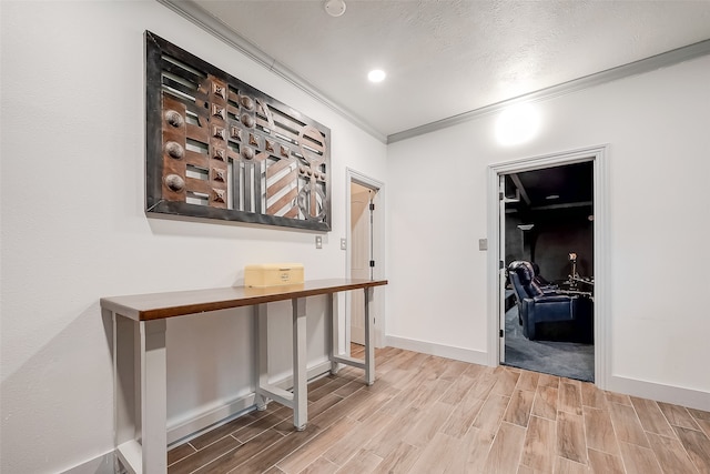 hall with light wood-type flooring and crown molding