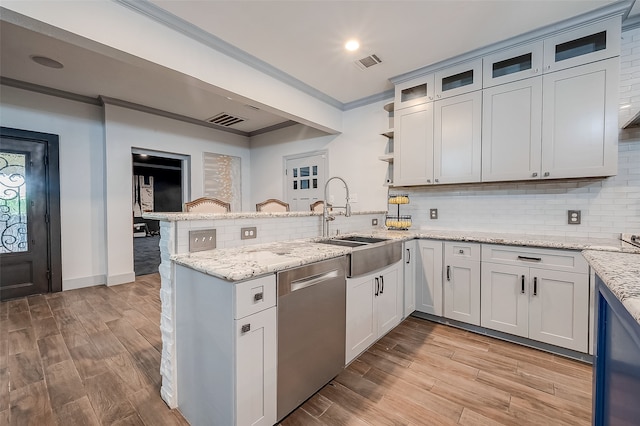 kitchen featuring kitchen peninsula, white cabinets, sink, and stainless steel dishwasher