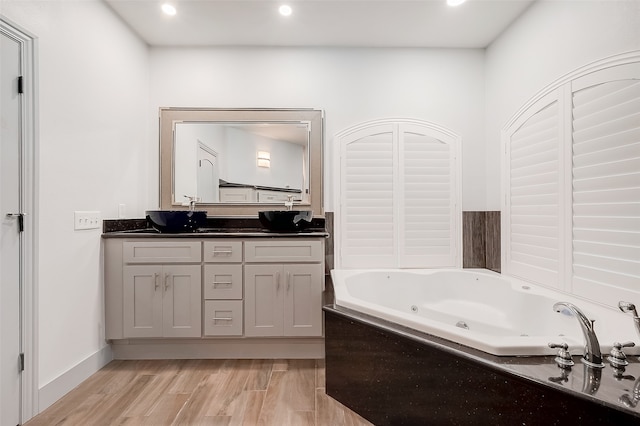 bathroom with a bathtub, vanity, and wood-type flooring