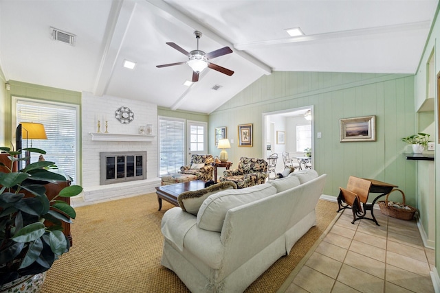 living room with a fireplace, lofted ceiling with beams, ceiling fan, and light tile patterned floors