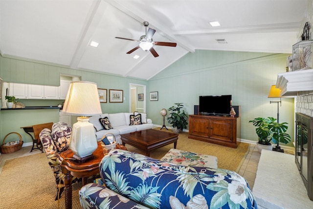 tiled living room with a fireplace, ceiling fan, and vaulted ceiling with beams