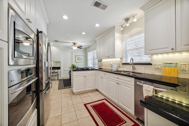 kitchen featuring sink, white cabinets, light tile patterned flooring, and stainless steel appliances