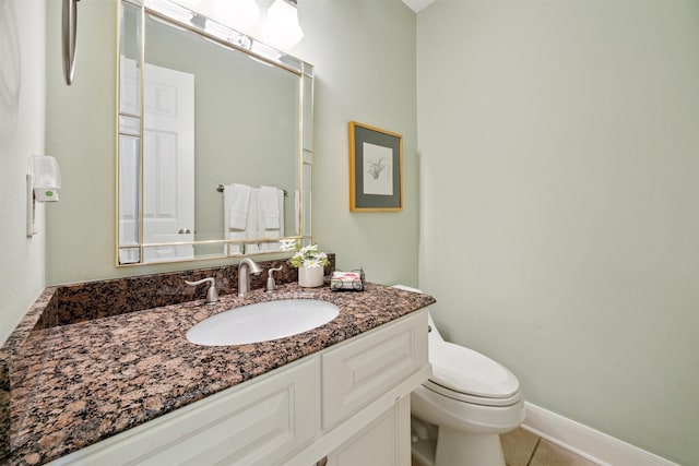 bathroom featuring tile patterned flooring, vanity, and toilet