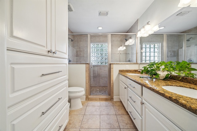 bathroom with toilet, an enclosed shower, tile patterned flooring, and vanity