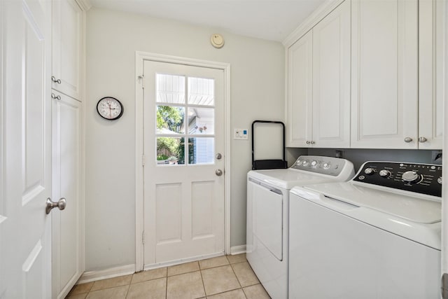 laundry room with cabinets, washer and clothes dryer, and light tile patterned floors