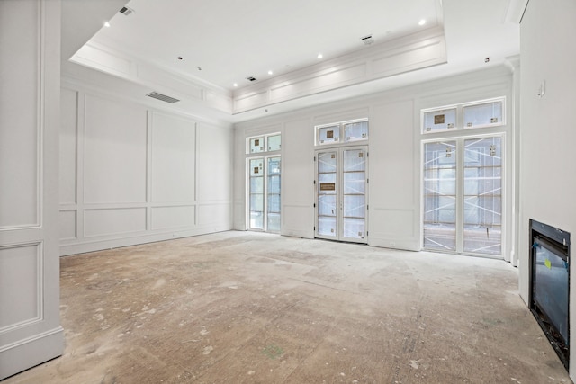 unfurnished living room featuring a tray ceiling and ornamental molding