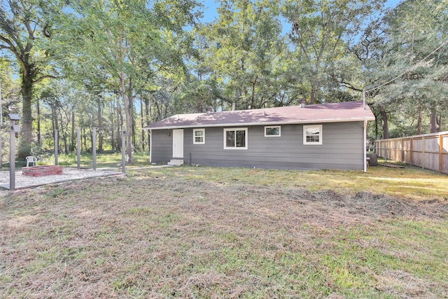 rear view of property featuring a lawn