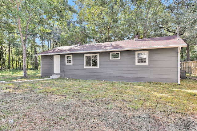 rear view of house with a lawn and central AC