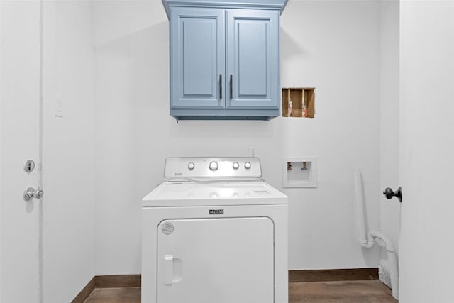 laundry area featuring cabinets, dark hardwood / wood-style flooring, and washer / dryer