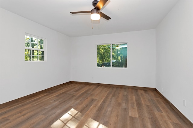 empty room with ceiling fan and dark hardwood / wood-style flooring