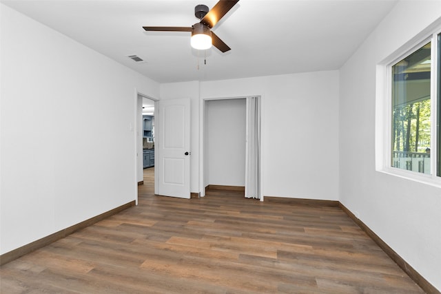 unfurnished bedroom featuring ceiling fan, dark wood-type flooring, and a closet