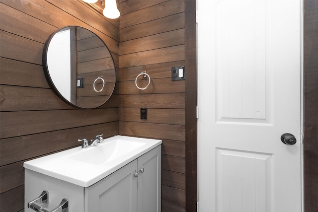 bathroom featuring wood walls and vanity