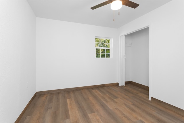 unfurnished room with ceiling fan and dark wood-type flooring