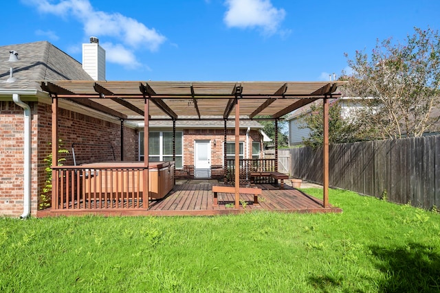 rear view of property with a pergola, a deck, and a lawn