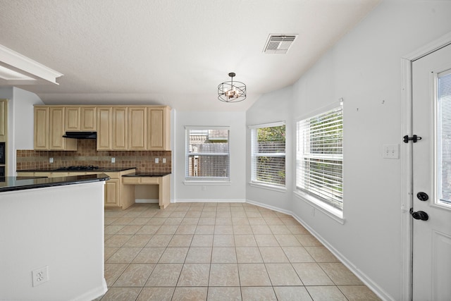 kitchen featuring light tile patterned flooring, hanging light fixtures, vaulted ceiling, and tasteful backsplash