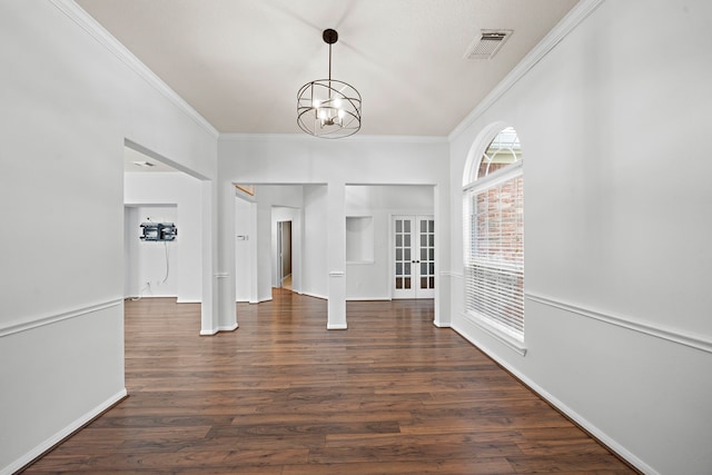 interior space with ornamental molding, french doors, an inviting chandelier, and dark hardwood / wood-style flooring