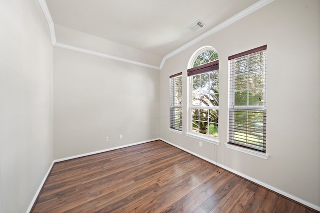 spare room featuring ornamental molding and dark wood-type flooring