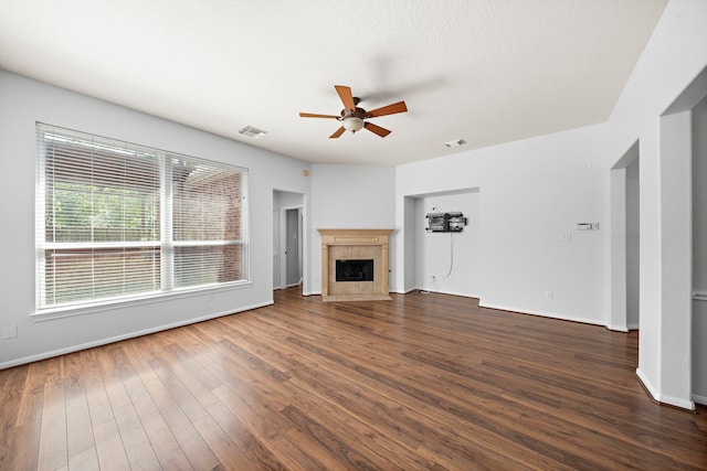 unfurnished living room featuring dark wood-type flooring, a fireplace, and ceiling fan