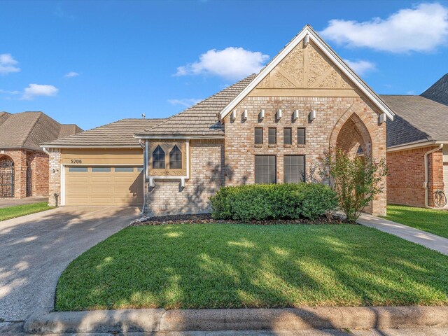 view of front of house featuring a garage and a front lawn