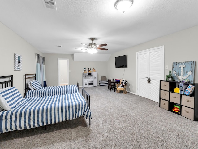 carpeted bedroom featuring ceiling fan, a textured ceiling, and vaulted ceiling