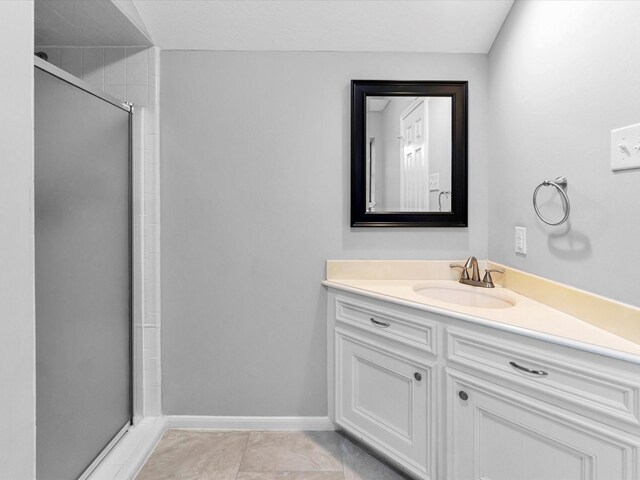 bathroom featuring tile patterned floors, a shower with door, and vanity