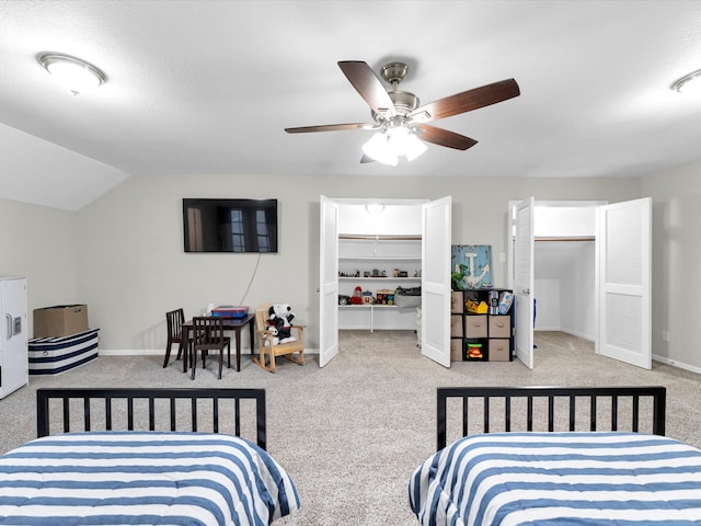 carpeted bedroom with a textured ceiling, vaulted ceiling, and ceiling fan