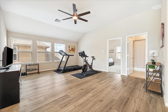 exercise room with ceiling fan, vaulted ceiling, and light hardwood / wood-style flooring