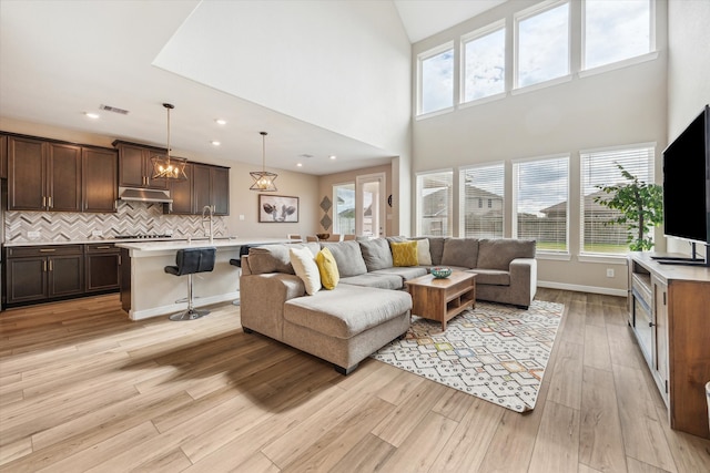 living room featuring light hardwood / wood-style floors and a high ceiling