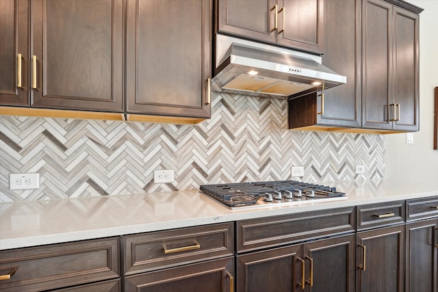 kitchen featuring stainless steel gas stovetop, exhaust hood, dark brown cabinets, and decorative backsplash