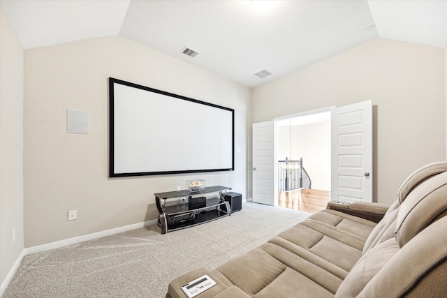 cinema room featuring lofted ceiling and carpet