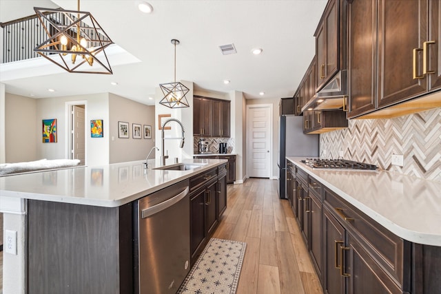 kitchen featuring pendant lighting, an island with sink, and sink