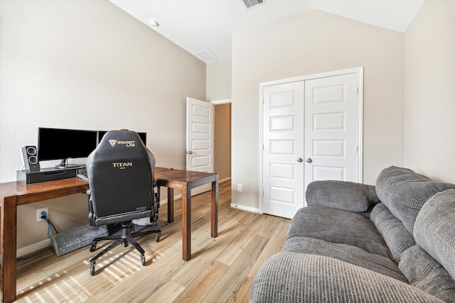 office with lofted ceiling and light hardwood / wood-style floors