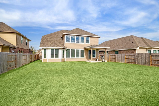 rear view of property with a yard and a patio area