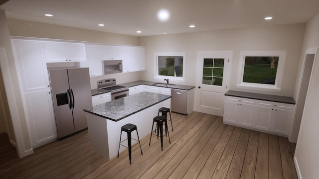 kitchen with sink, white cabinetry, a kitchen breakfast bar, stainless steel appliances, and a center island