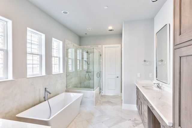 bathroom featuring vanity and independent shower and bath