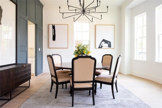 dining space with a chandelier, ornamental molding, a healthy amount of sunlight, and light hardwood / wood-style floors