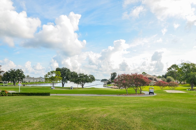 view of home's community featuring a water view and a lawn