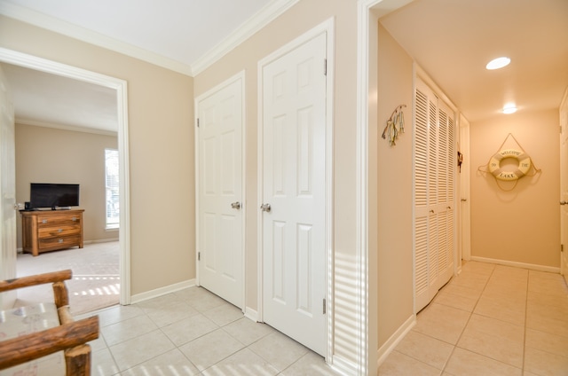 corridor featuring ornamental molding and light tile patterned floors