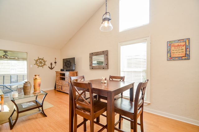 dining room featuring high vaulted ceiling, light wood-type flooring, and ceiling fan