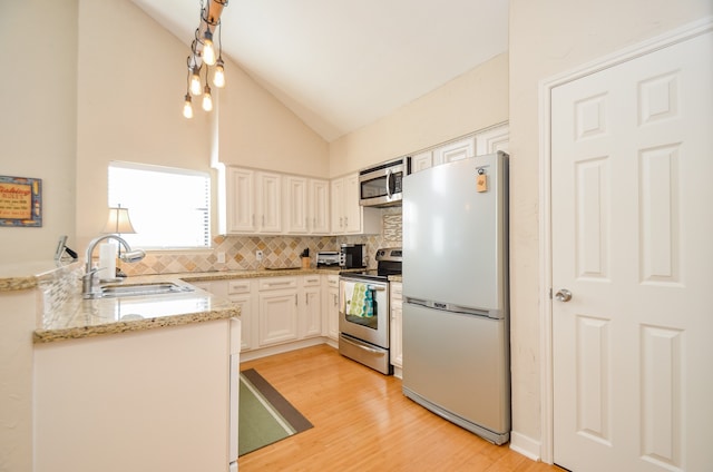 kitchen featuring white cabinets, sink, light hardwood / wood-style flooring, backsplash, and stainless steel appliances