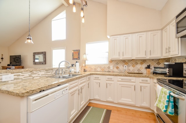 kitchen featuring light hardwood / wood-style floors, pendant lighting, sink, stainless steel appliances, and high vaulted ceiling