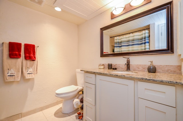 bathroom featuring vanity, tile patterned flooring, toilet, and decorative backsplash