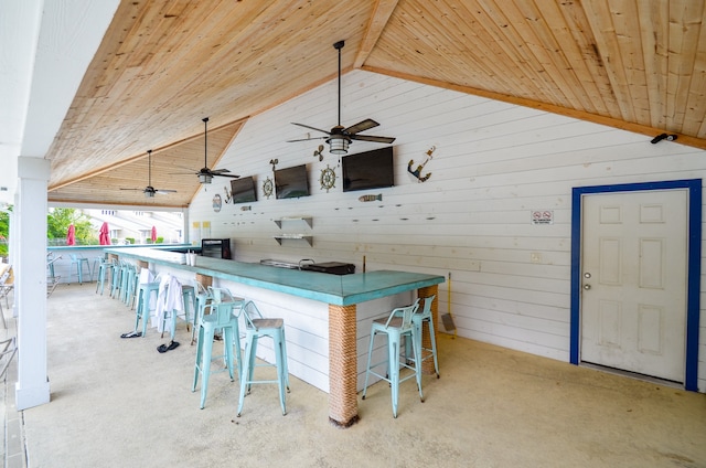 bar with ceiling fan, wood ceiling, high vaulted ceiling, and light colored carpet