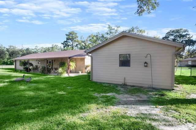 back of property with a yard and a patio area