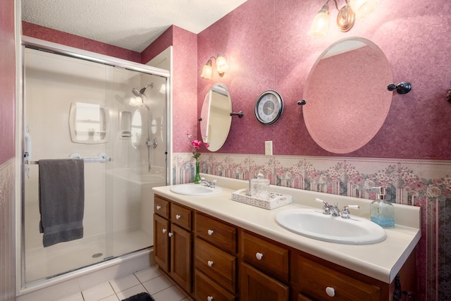 bathroom featuring walk in shower, vanity, a textured ceiling, and tile patterned floors