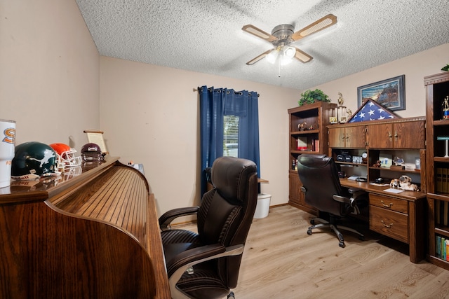 office space featuring ceiling fan, light wood-type flooring, and a textured ceiling