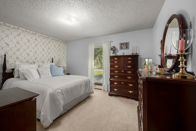 bedroom with light colored carpet and a textured ceiling